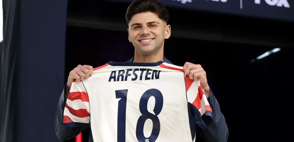 Jugador sostiene camiseta con el nombre ARFSTEN