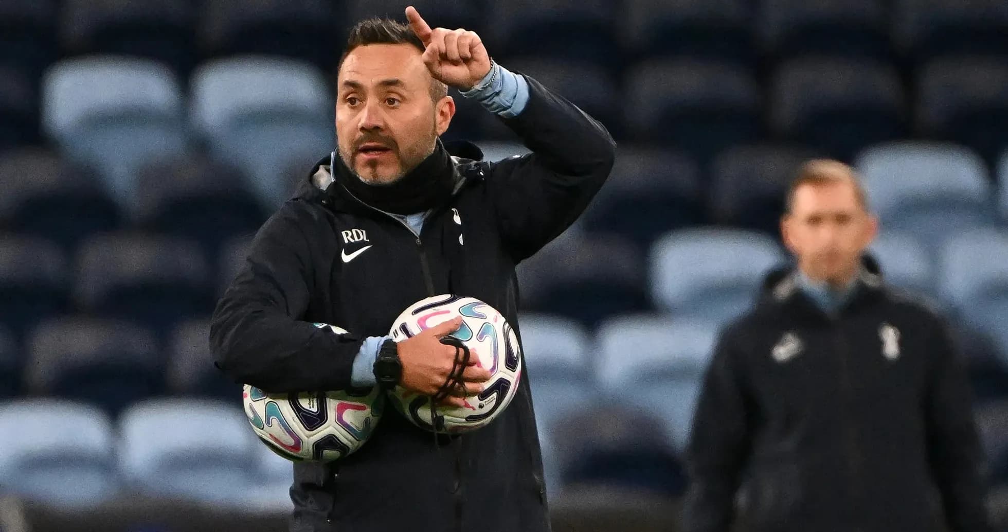 Entrenador dirigiendo una sesión de entrenamiento con balones