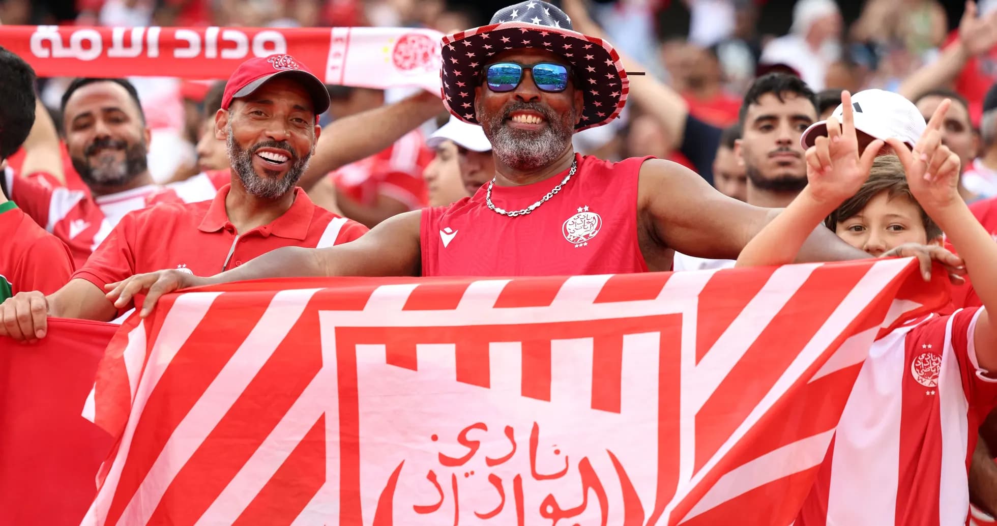 Aficionados animando con banderas en el estadio