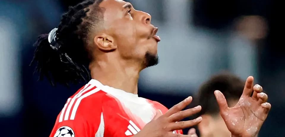 Jugador de fútbol levantando las manos en el campo
