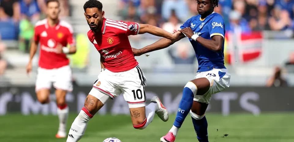 Jugador de Manchester United driblando mientras es marcado