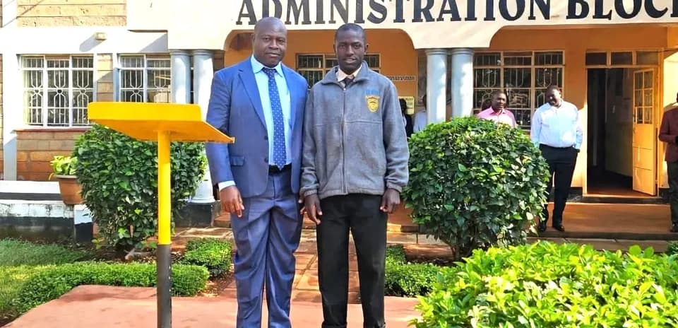 Dos hombres posando frente a la escuela secundaria