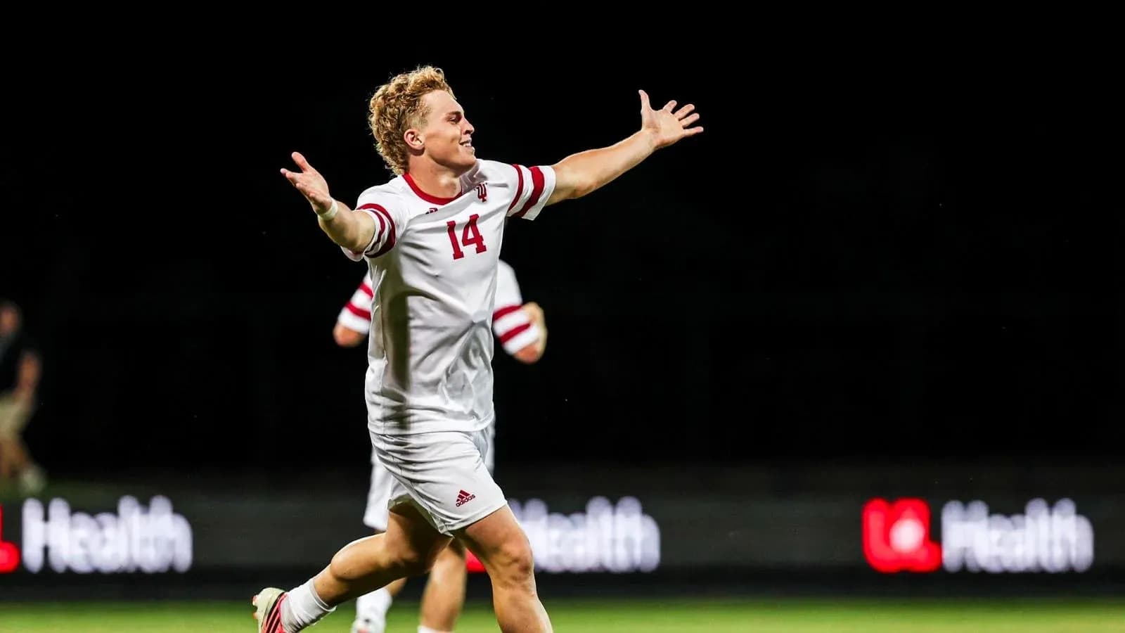 Jugador celebrando con los brazos abiertos en el campo