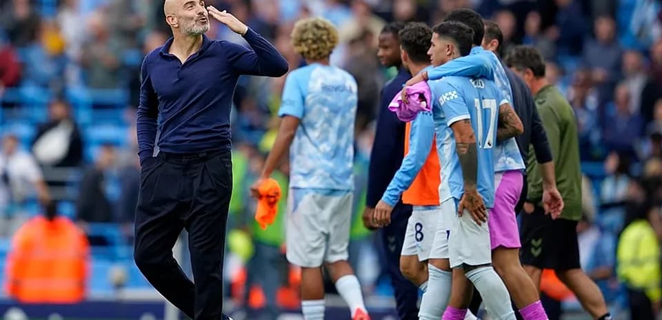 Entrenador saludando a jugadores de Manchester City