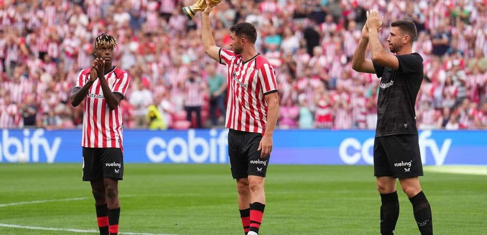 Jugadores de Athletic Club celebrando con trofeo en el campo