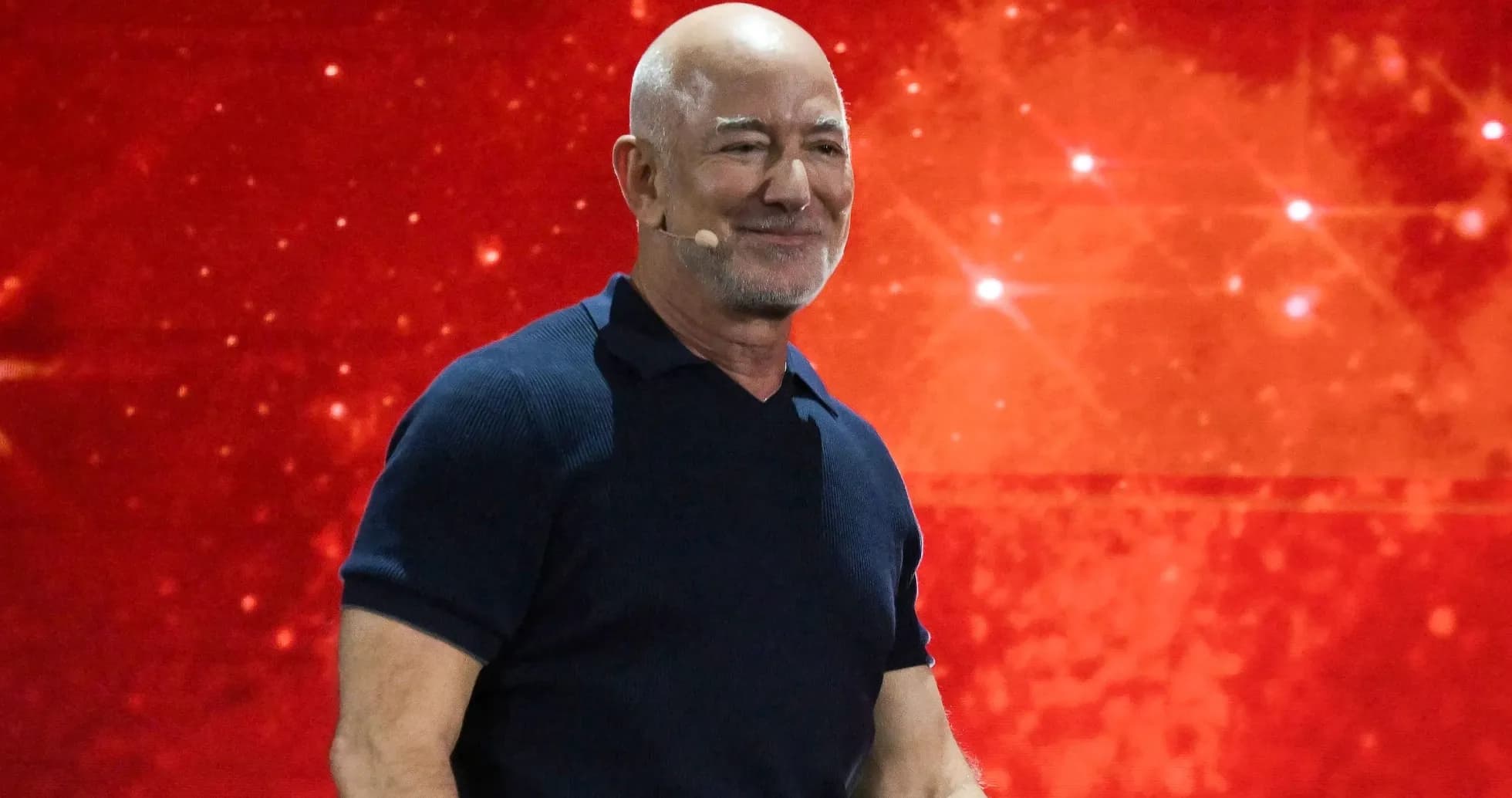 Hombre en escenario con fondo rojo durante presentación