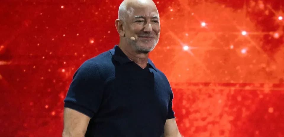 Hombre en escenario con fondo rojo durante presentación