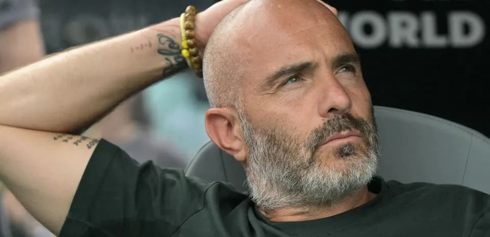 Entrenador pensativo en el banquillo durante el partido