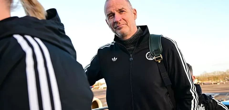Entrenador esperando en el aeropuerto con equipo