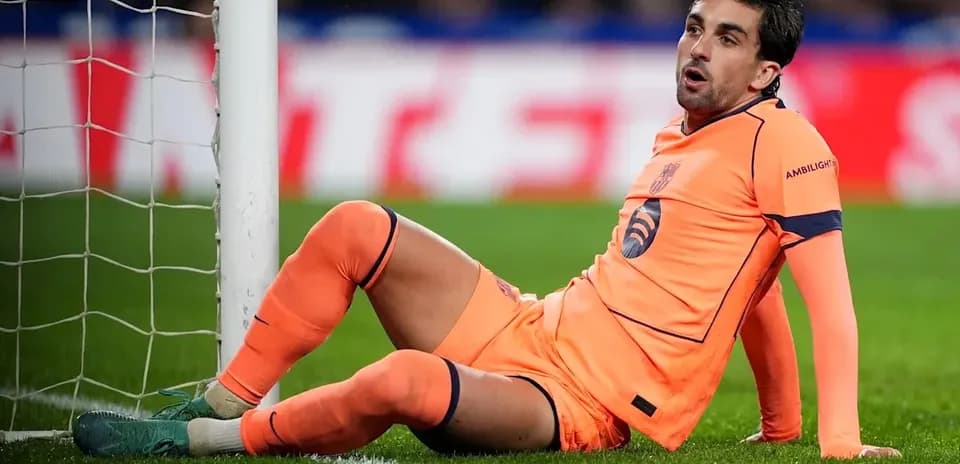Jugador sentado en el campo junto a la portería