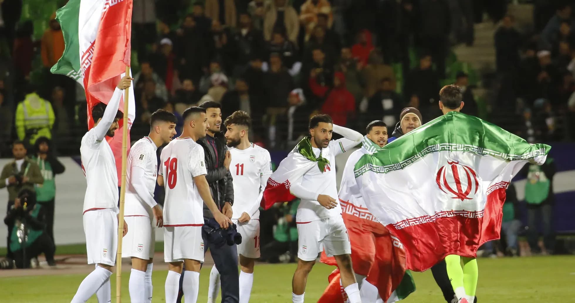 Jugadores de Irán celebrando con banderas