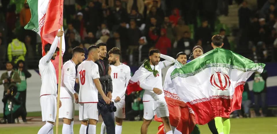 Jugadores de Irán celebrando con banderas