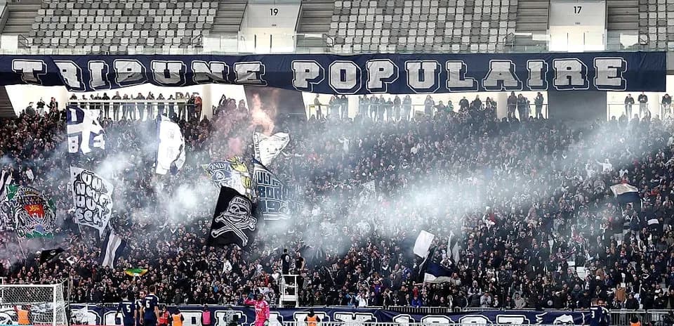 Aficionados con banderas y humo en el estadio