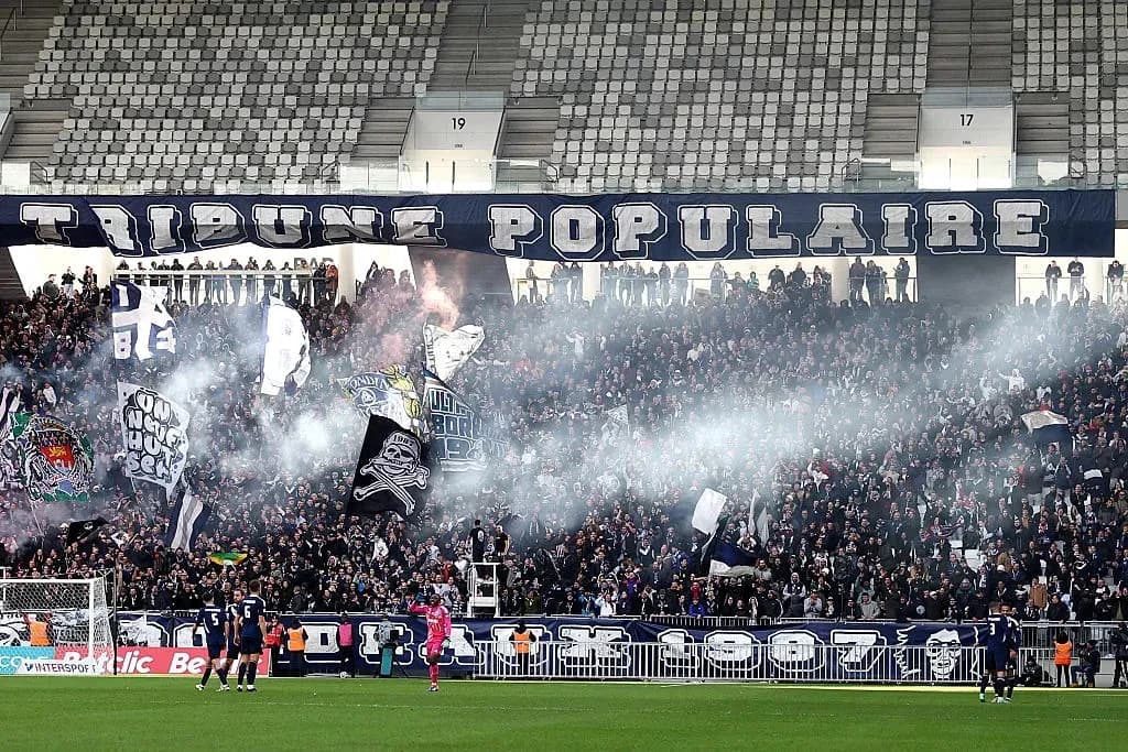 Aficionados con banderas y humo en el estadio
