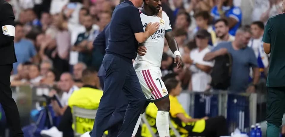 Entrenador hablando con jugador durante partido en estadio