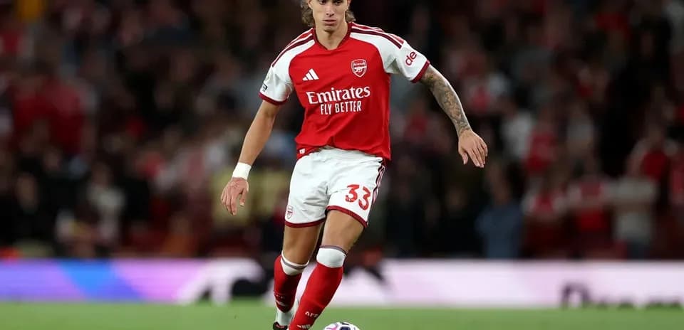 Jugador del Arsenal corriendo con el balón en campo