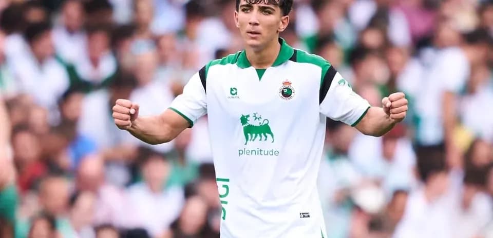 Jugador celebrando en partido con afición de fondo