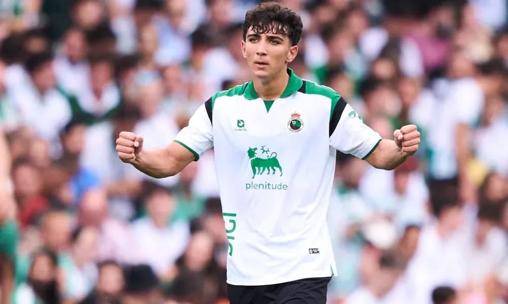 Jugador celebrando en partido con afición de fondo