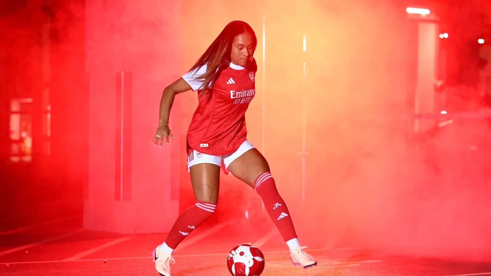 Jugadora de fútbol de Arsenal en humo rojo