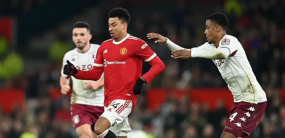 Jugador de Manchester United driblando a rival de Aston Villa