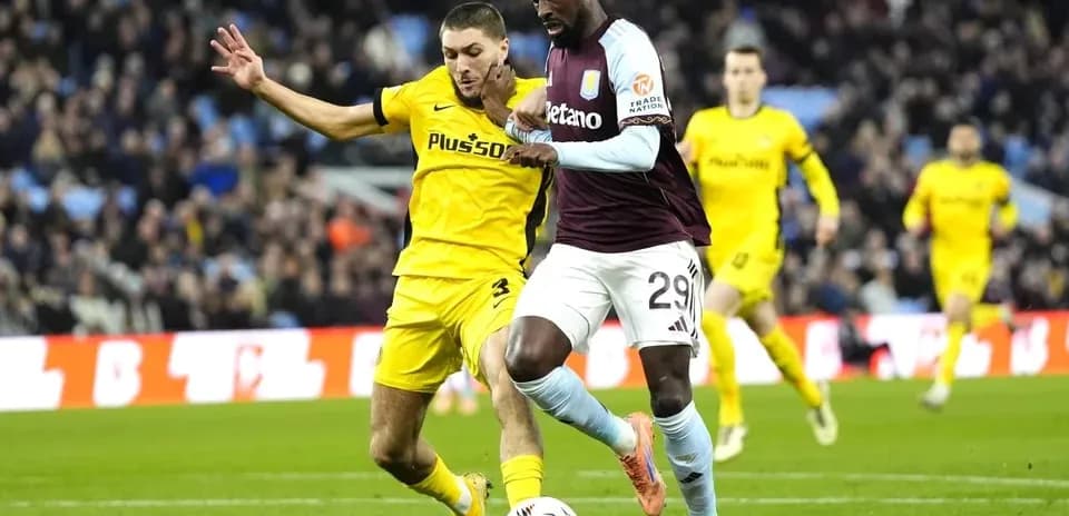 Jugador de Aston Villa driblando con el balón en partido
