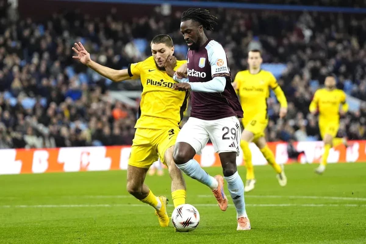 Jugador de Aston Villa driblando con el balón en partido