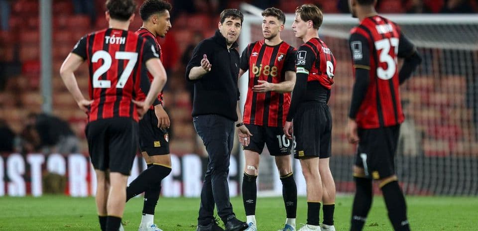 Entrenador hablando con jugadores de Bournemouth en el campo