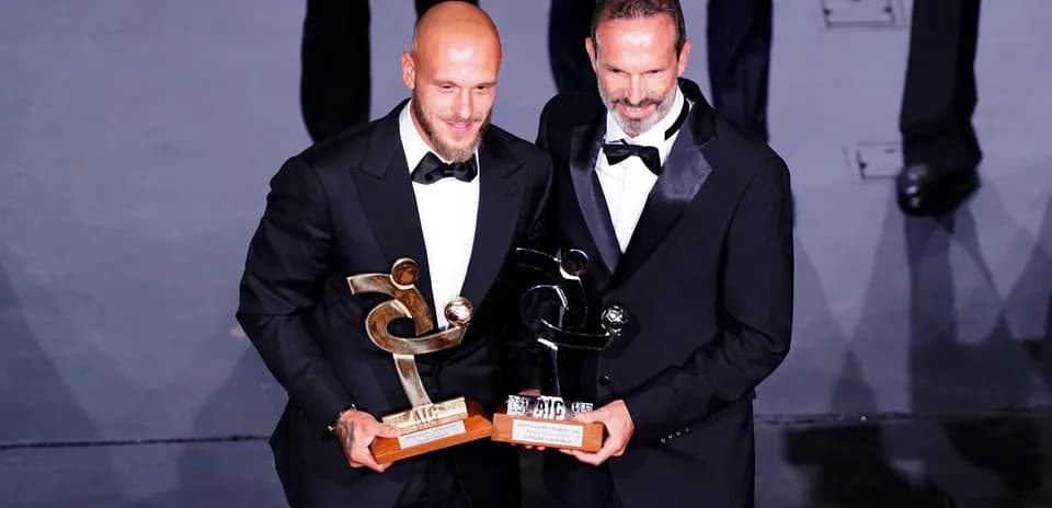 Dos hombres con premios en ceremonia de gala