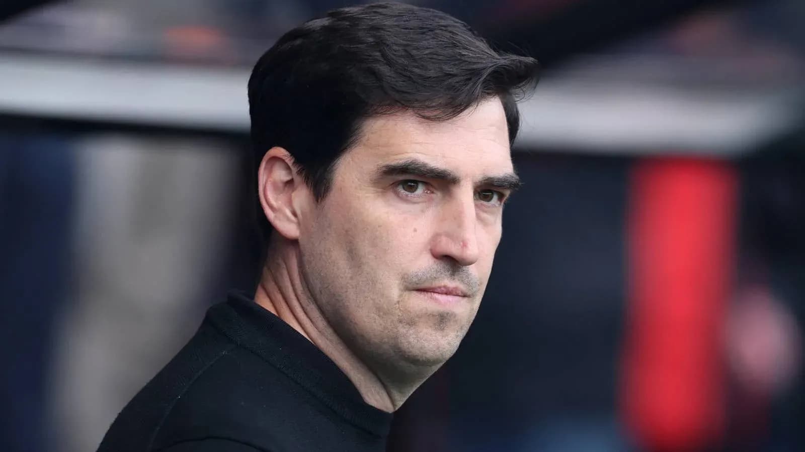 Entrenador observando desde el banquillo durante el partido