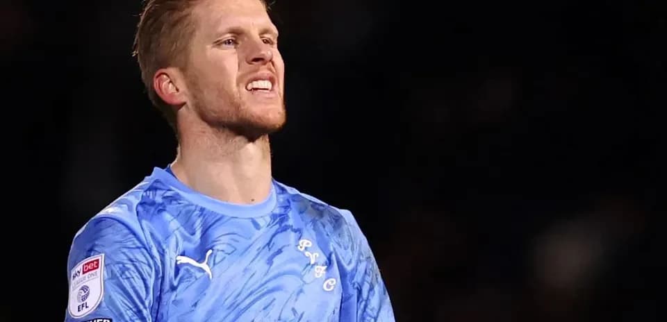 Portero con camiseta azul en el campo de fútbol