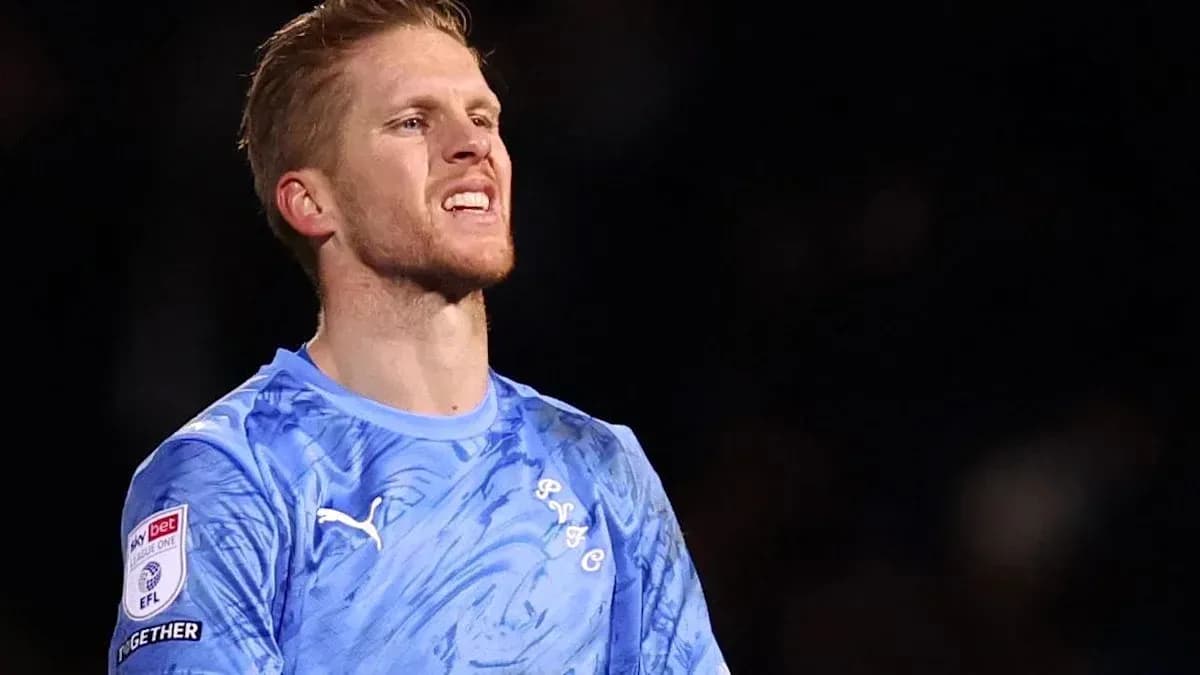 Portero con camiseta azul en el campo de fútbol