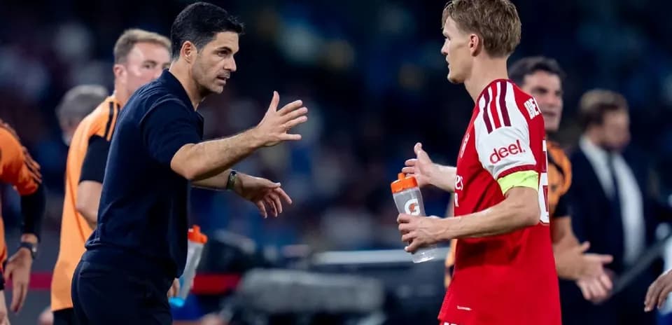 Entrenador hablando con jugador en la banda