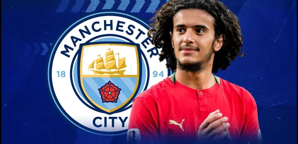 Jugador de Manchester City frente al logo del club