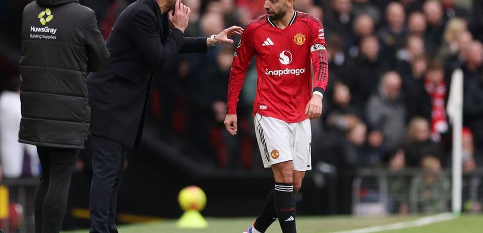 Entrenador dando instrucciones a jugador del Manchester United