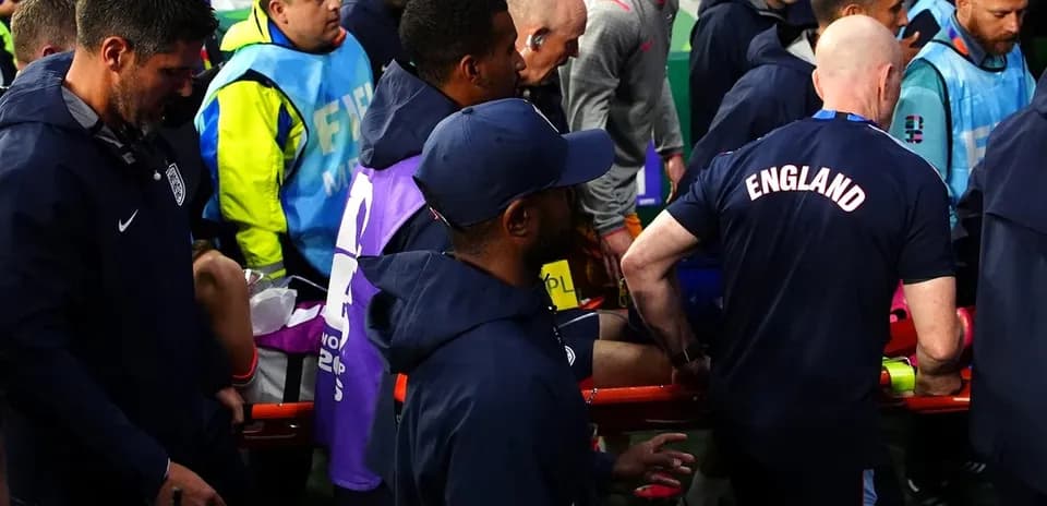 Personal médico trasladando a jugador en camilla