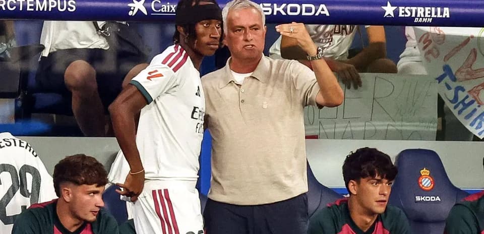 Entrenador instruyendo a jugador en el banquillo