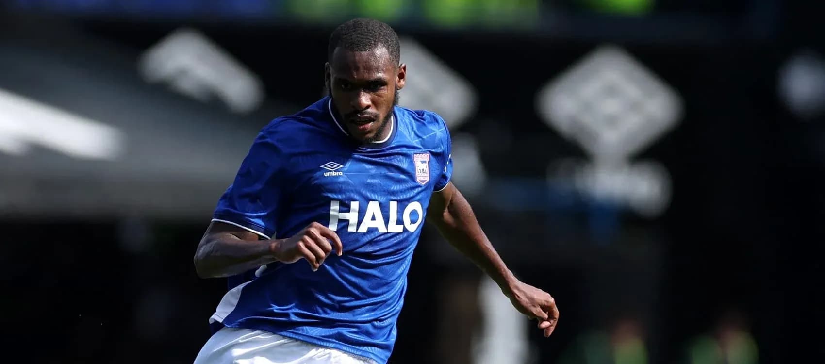 Jugador corriendo con camiseta azul de Ipswich Town