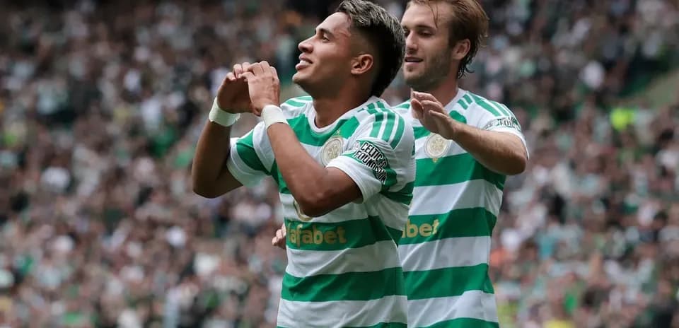 Jugador celebrando un gol con compañero en el estadio
