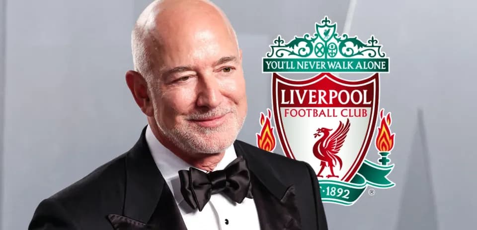 Hombre en traje con logo del Liverpool FC de fondo