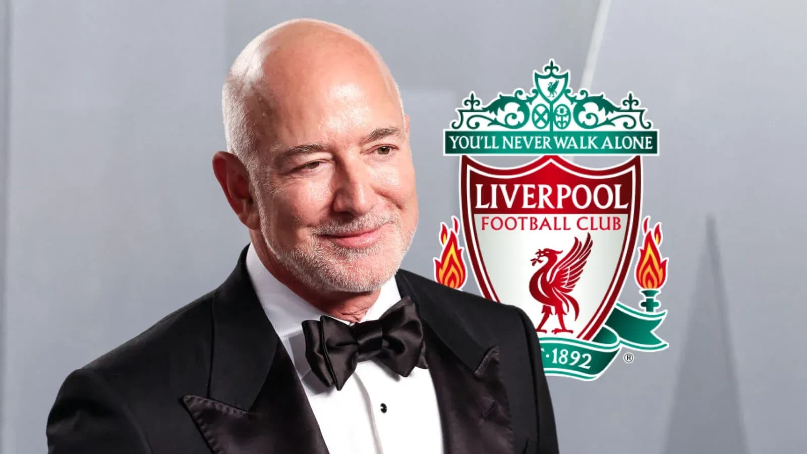 Hombre en traje con logo del Liverpool FC de fondo