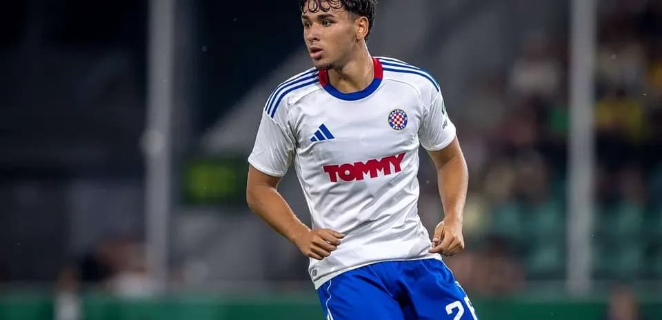 Jugador de fútbol corriendo en camiseta blanca y azul
