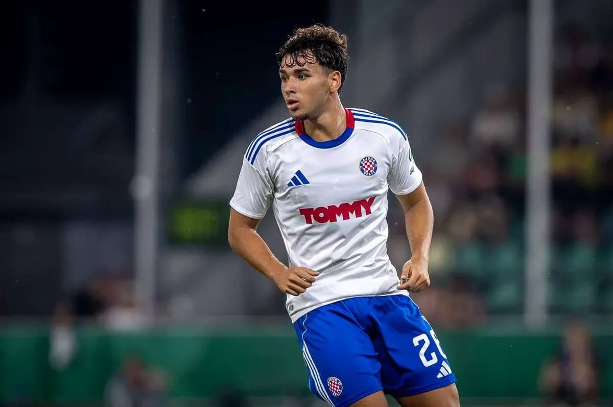 Jugador de fútbol corriendo en camiseta blanca y azul