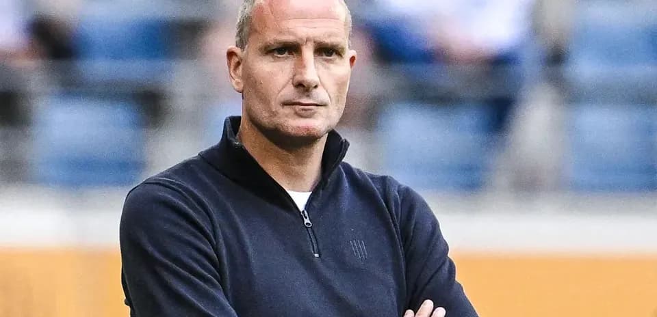 Entrenador observando el partido con brazos cruzados