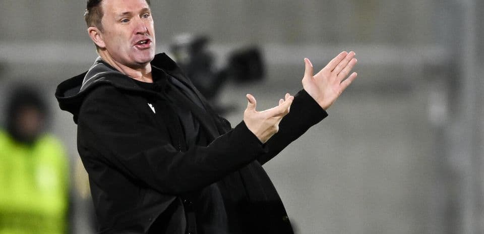 Entrenador dirigiendo a su equipo desde la línea lateral