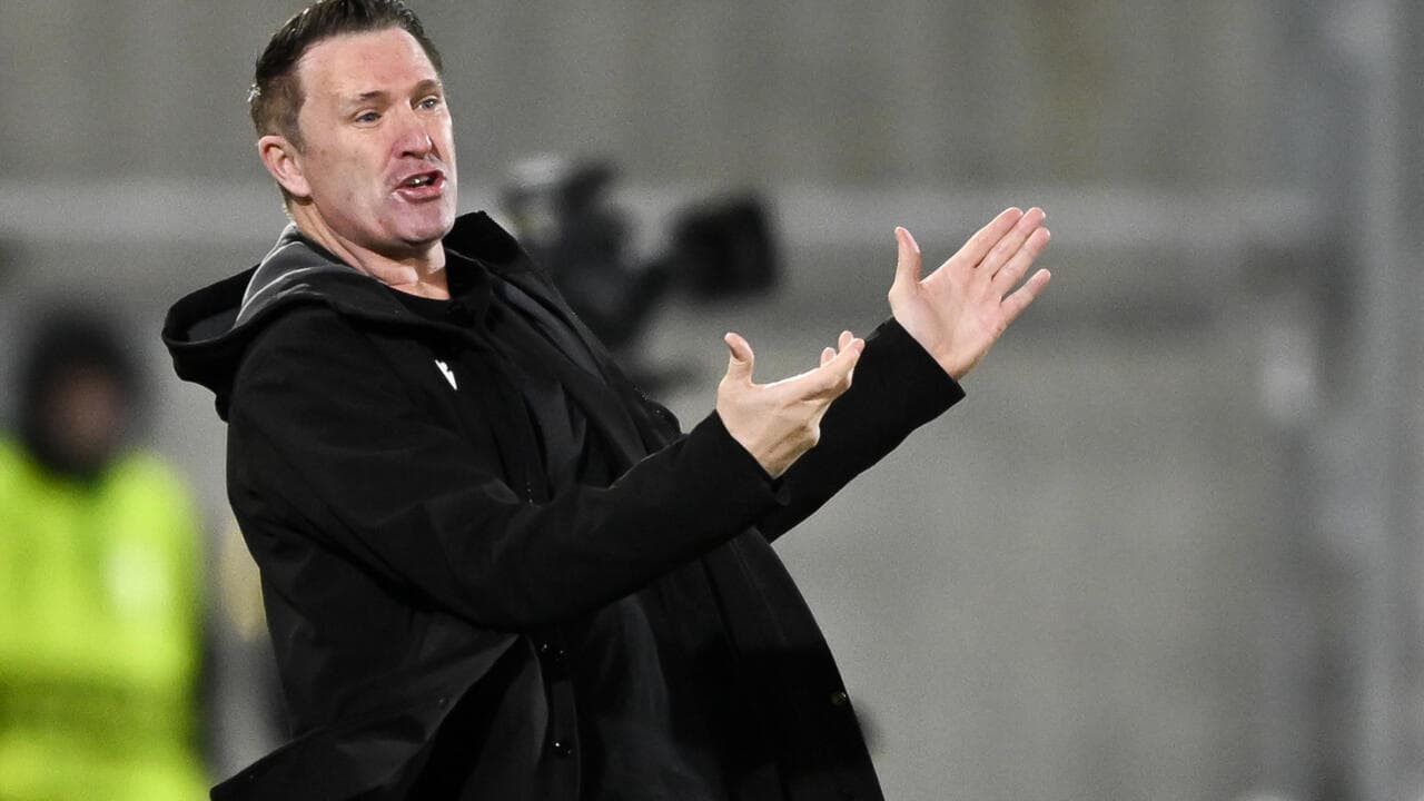 Entrenador dirigiendo a su equipo desde la línea lateral