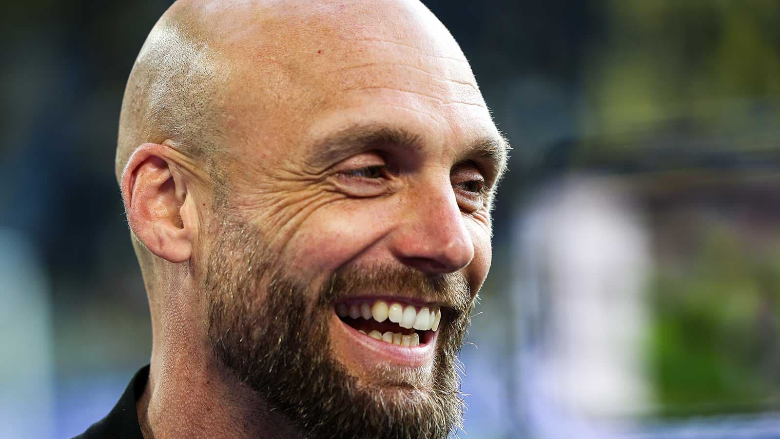 Hombre sonriendo en un entorno deportivo