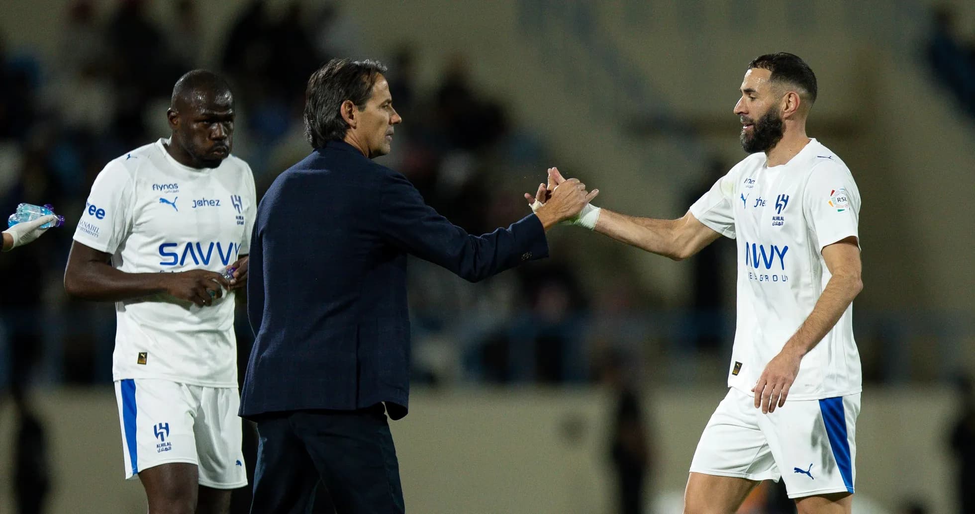 Entrenador saludando a jugador en el campo