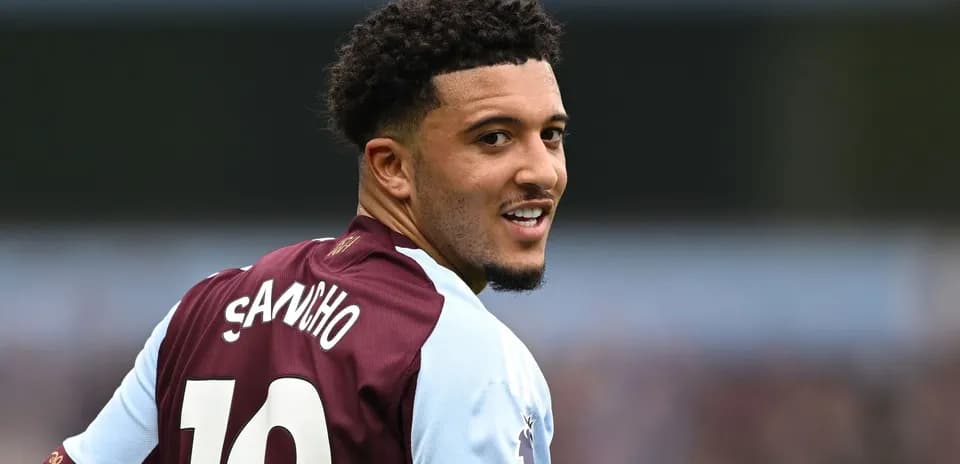 Jugador con camiseta de Aston Villa sonriendo hacia atrás