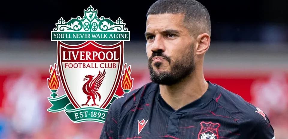 Jugador con camiseta negra junto al escudo de Liverpool