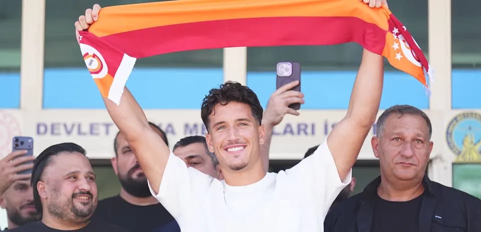 Jugador sosteniendo una bufanda de Galatasaray